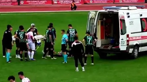Saha kenarında sedyeyle taşınan futbolcuya müdahale eden sağlık ekipleri