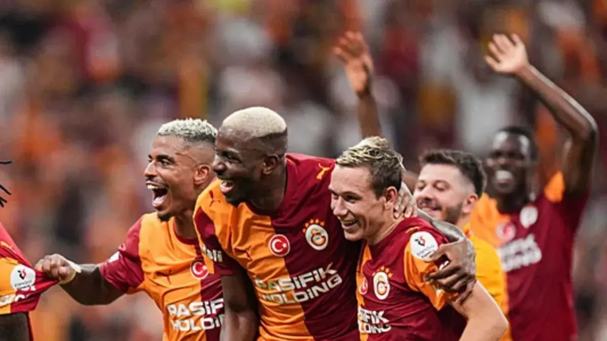 Aleksey Batrakov Galatasaray formasıyla sahada ve takım arkadaşlarıyla gülümserken