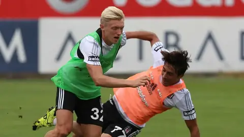 Andreas Beck röportaj verirken, arka planda futbol stadyumu görüntüsü