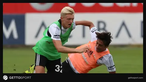 Andreas Beck röportaj verirken, arka planda futbol stadyumu görüntüsü
