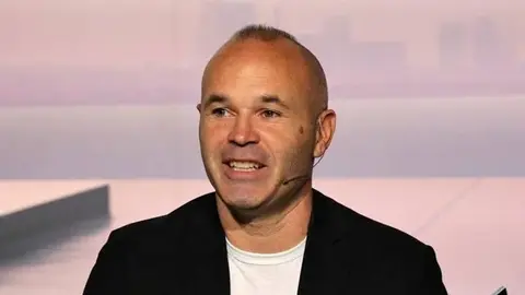 Andres Iniesta tribunada danışır, arxa planda stadion