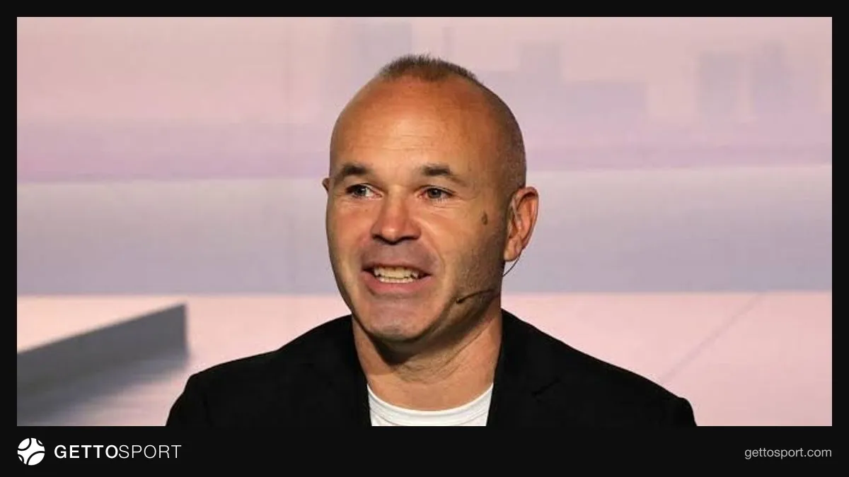 Andres Iniesta tribunada danışır, arxa planda stadion