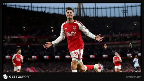 Arsenal stadionu qarşısında klub loqosu və işçilər