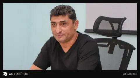 Aslan Kərimov müsahibə verərkən, meydan və futbol topu fonunda