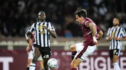 Futbol meydançasında Atalanta və Torino oyunçuları, topa hücum anı
