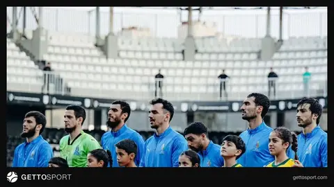 Ayxan Abbasov meydanda düşünərkən, arxada futbolçular və tribuna