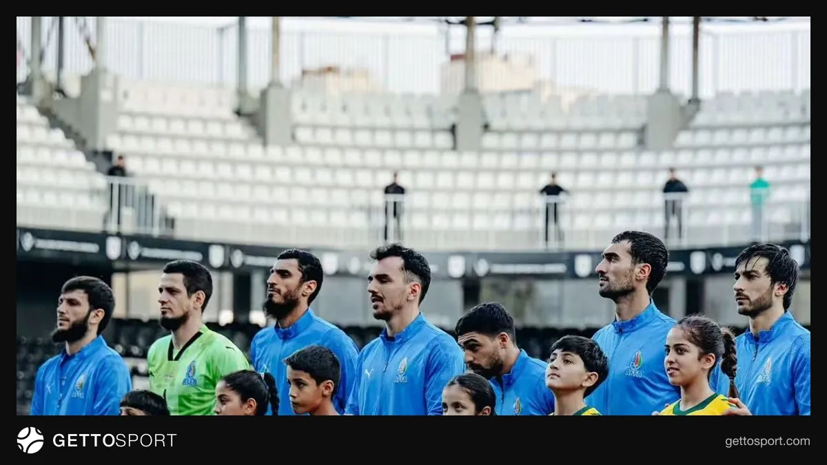 Ayxan Abbasov meydanda düşünərkən, arxada futbolçular və tribuna