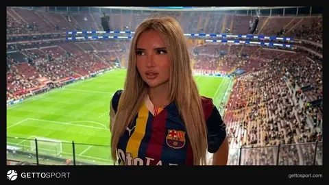 Yarı Fenerbahçe yarı Barcelona forması giymiş bir kadın taraftar tribünde