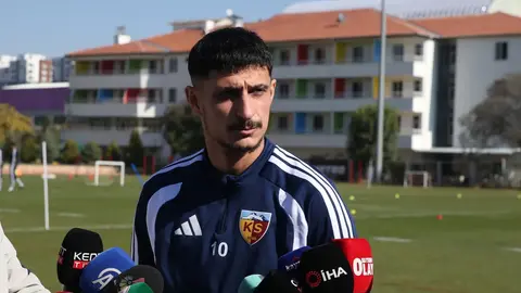 Benhur Keser mikrofon veya sosyal medya paylaşımını işaret eder şekilde takım formasıyla