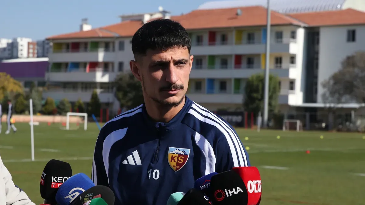 Benhur Keser mikrofon veya sosyal medya paylaşımını işaret eder şekilde takım formasıyla