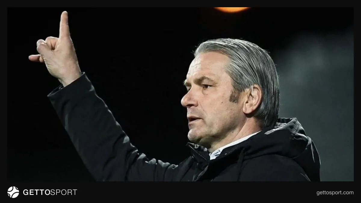 Bernd Stork yanında Gənclərbirliyi loqosu və futbol stadionu
