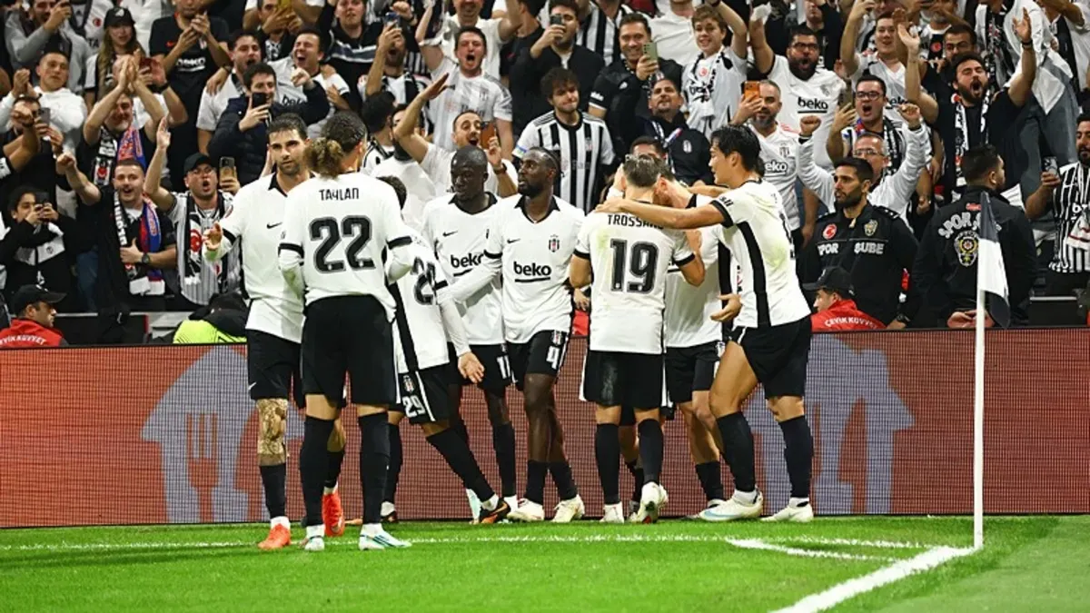 Beşiktaş oyuncuları maç sırasında topa müdahale ederken, statta taraftarlar