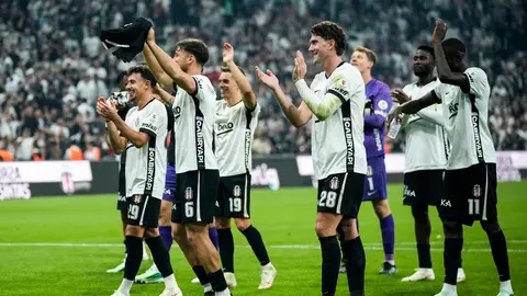 Beşiktaş futbol takımı formalarıyla sahada, üstlerinde siyah-beyaz renkler