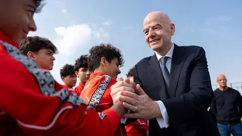 Canni İnfantino mikrofon qarşısında çıxış edir, arxa fonda U-15 Festivalının loqosu