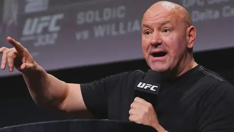 Dana Uayt mətbuat konfransında danışır, arxa planda UFC loqosu