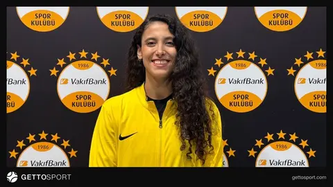 Deniz Uyanık forma ile voleybol sahasında takım arkadaşlarıyla konuşurken