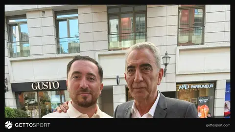 Emil Əsədov müsahibə verir, arxa planda futbol stadionu