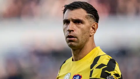 Bandajlı çene ve eldivenli elini tutan Emiliano Martínez