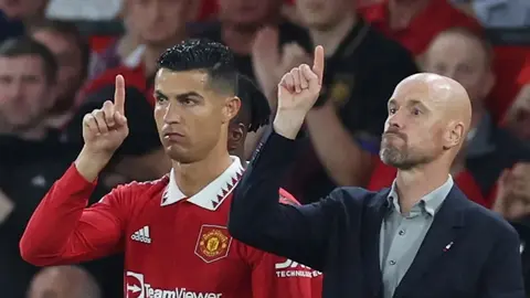 Erik ten Hag röportaj verirken, arka planda Manchester United logosu