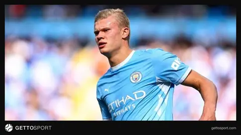 Erling Haaland basın toplantısında konuşurken, arka planda Manchester City rozeti