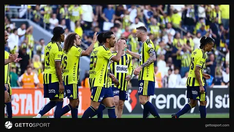 Fenerbahçe forması giymiş futbolcular sahada ısınırken