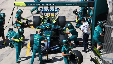 Fernando Alonso müsahibədə yellənir, arxa planda bolid və yarış trası