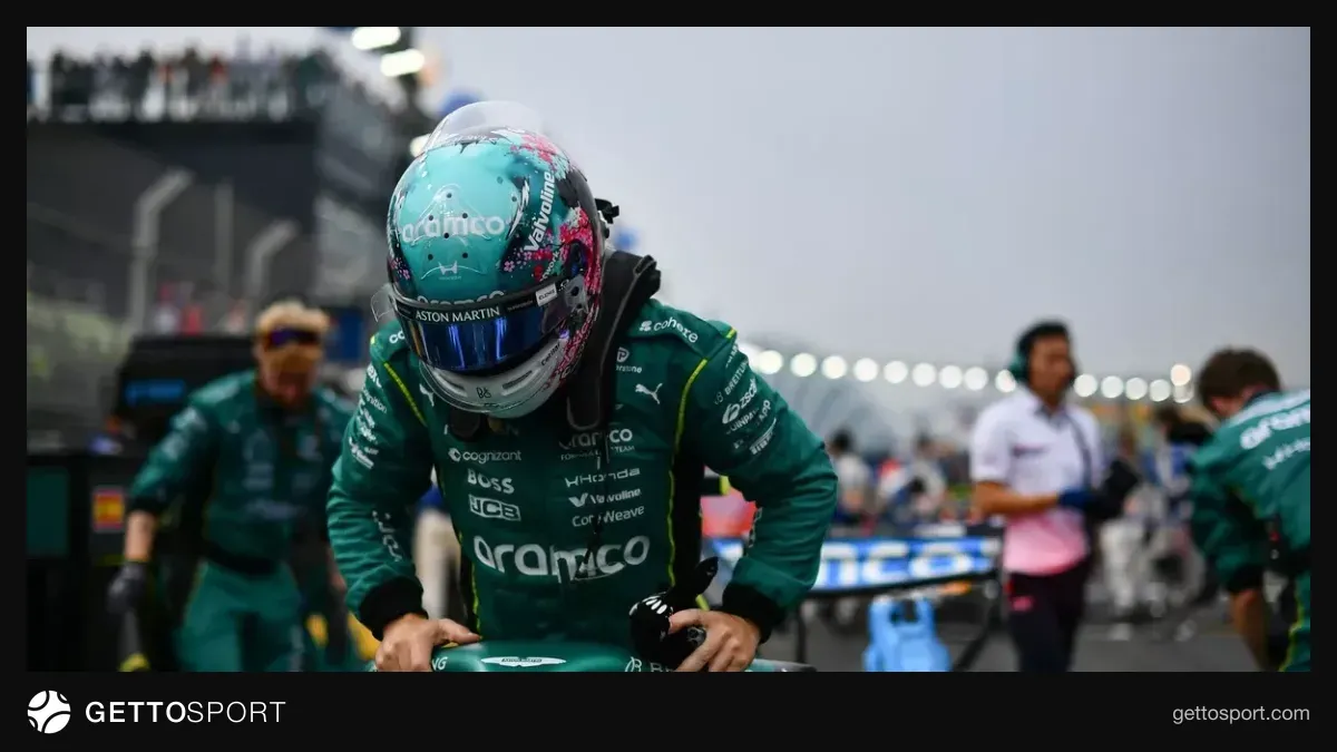 Fernando Alonso mikrofon qarşısında müsahibə verir, arxa planda Aston Martin loqosu