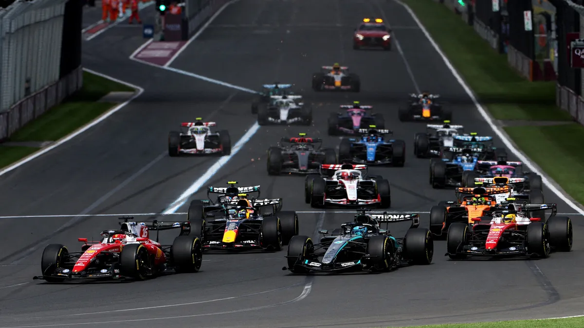 FIA Başkanı Mohammed Ben Sulayem konuşurken, arka planda Formula 1 aracı silueti