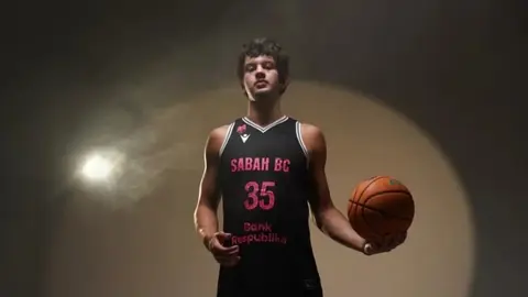 Frenki Fidler topu driblinq edərkən Sabahin ağ-formalı oyunçusu