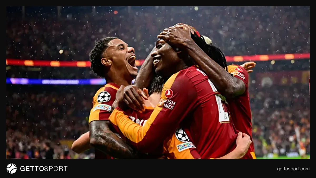 Galatasaray formasıyla sahada yürüyen futbolcular, tribünlerde taraftarlar