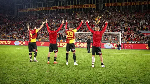 Göztepe forması giymiş futbolcular gol sonrası sevinç yaşarken