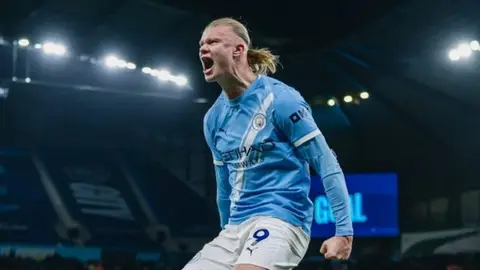 Erlinq Haland qol sevincində, arxa planda Barcelona forması