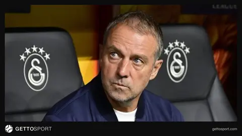 Hansi Flick basın toplantısında konuşuyor, arka planda Barcelona logosu