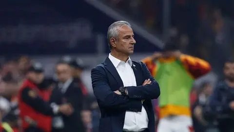 İsmail Kartal siyah takım elbise ile saha kenarında düşünceli