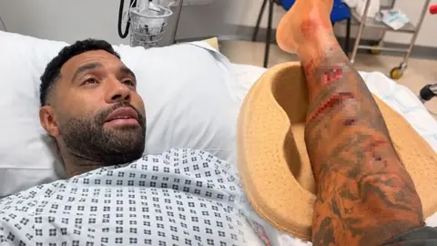 Bandajlı bacağıyla kanepeye oturmuş köpeği King ile Jermaine Pennant