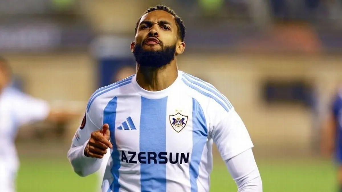 Juninyo Olavio futbol formasında, mikrofona danışarkən