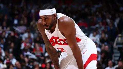 Kawhi Leonard dizini tutarken takım formasıyla kenarda oturuyor