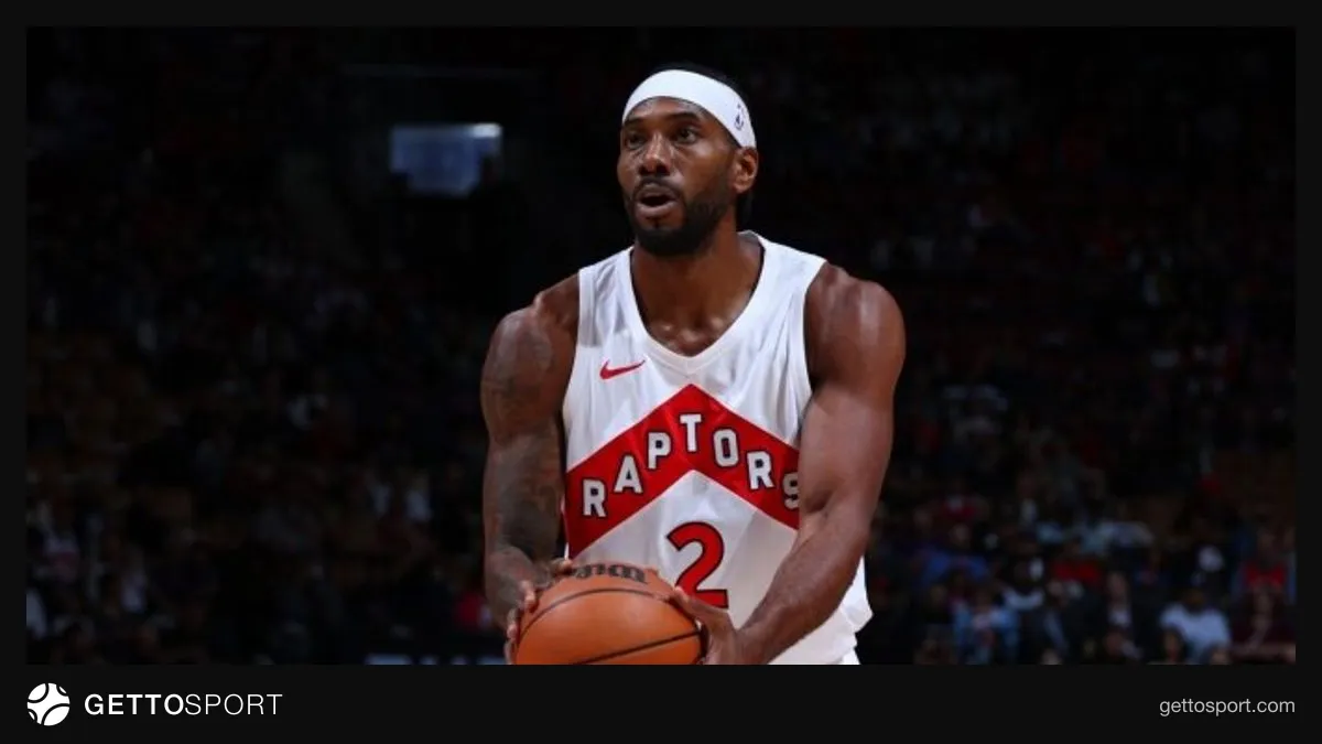 Kawhi Leonard Raptors formasıyla top sürerken, taraftarlar arkada