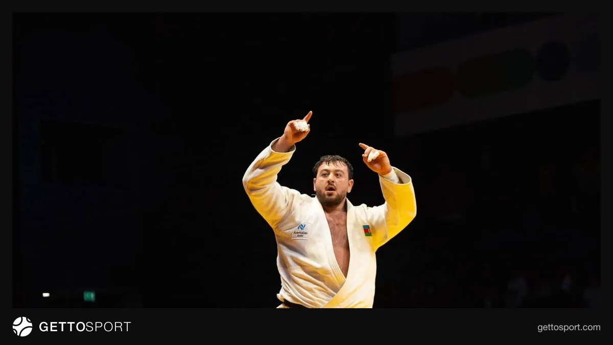 Kənan Qasımov medalı ilə tribunaya salam verir