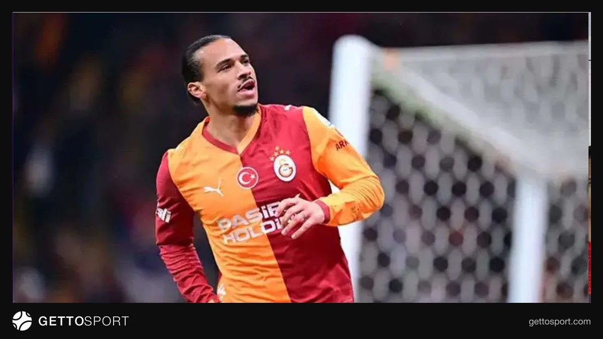 Galatasaray formasıyla Leroy Sane el sallıyor, taraftarlar arka planda