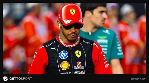 Lewis Hamilton kırmızı Ferrari takım kıyafetiyle pist kenarında telsiz konuşması