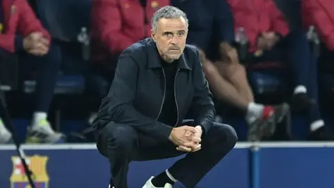 Luis Enrique basın toplantısında konuşurken futbol stadyumu arka planı