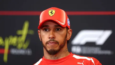 Lyuis Hemilton Ferrari libasında bolidin yanında danışır