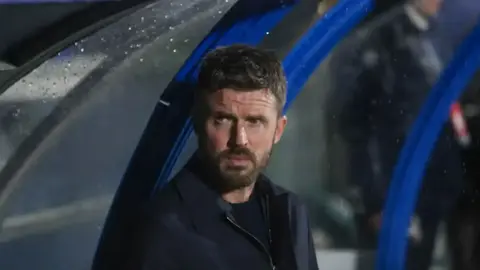 Maykl Karrik məşq zamanı Mançester Yunayted logo ilə stadionda