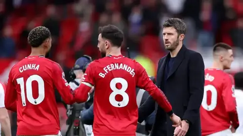 Mançester Yunayted oyunçuları məşq zamanı Old Trafford stadionu fonunda