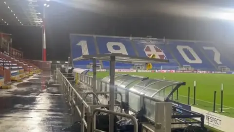 Como stadionunda yağış altında futbol meydançası və işıq dirəkləri