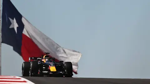 Max Ferstappen yarış maşını ilə trasda, komanda üzvləri ilə