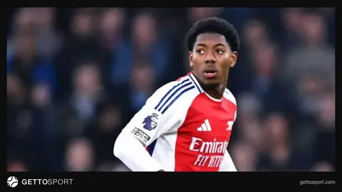 Mayls Lyuis-Skelli mikrofona danışır, arxa planda Arsenal loqosu
