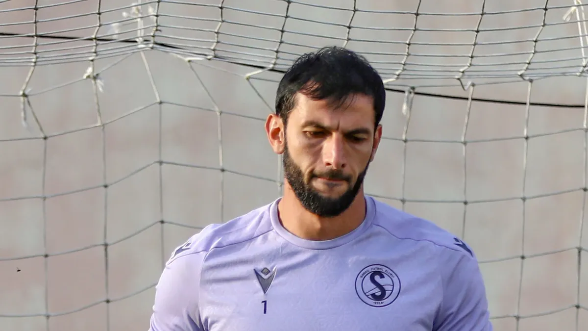 Mehdi Cənnətov qapıda topa baxır, narazı üz ifadəsi