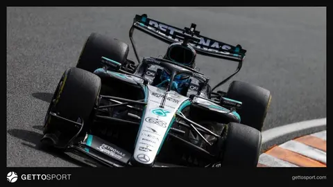Formula 1 bolidinin arxa qanadı və pitdə texniki işçilər